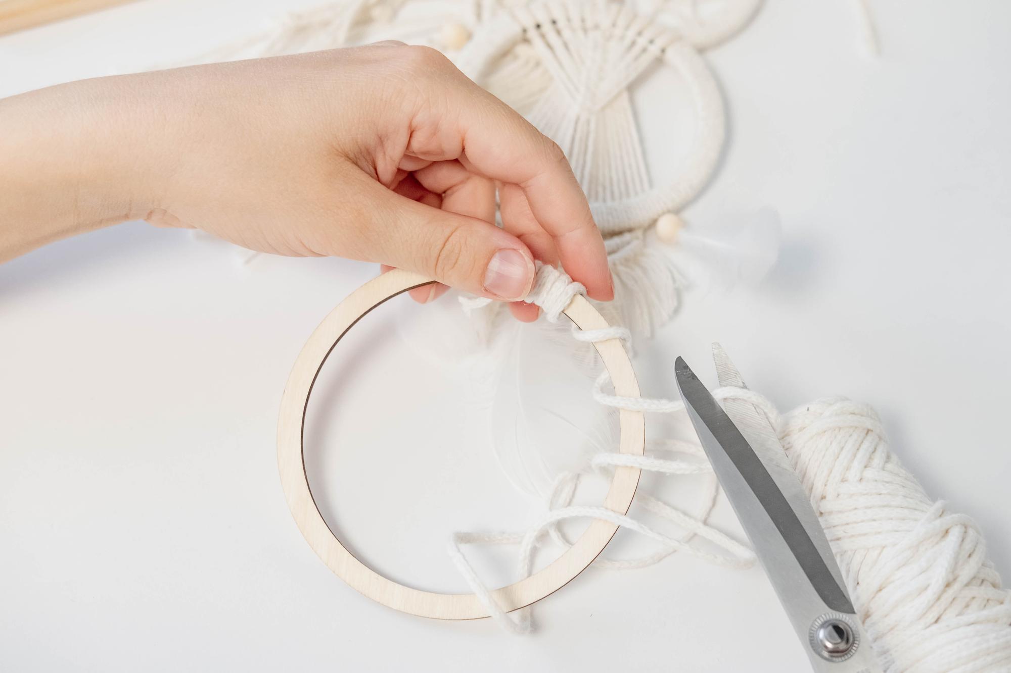 Studio hands preparing embroidery hoop and threads